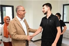 Antakya Belediyesi Başkanı İbrahim Naci Yapar evlerine kavuşan ailelerle fotoğraf çekerken