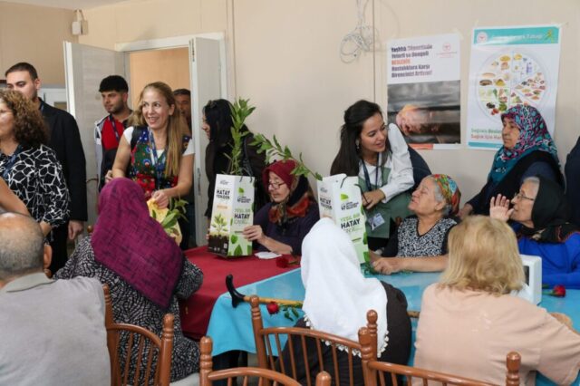 foto.jpg Hatay Büyükşehir Belediyesi yetkilileri huzurevi sakinlerine çiçek ve fidan verirken