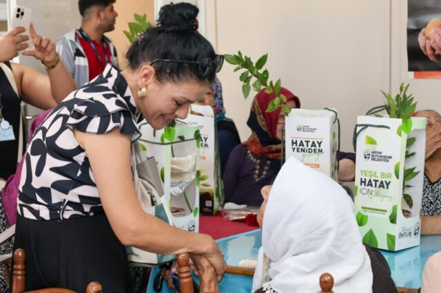 foto.jpg Hatay Büyükşehir Belediyesi yetkilileri huzurevi sakinlerine çiçek ve fidan verirken