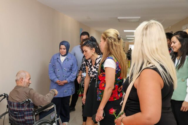 foto.jpg Hatay Büyükşehir Belediyesi yetkilileri huzurevi sakinlerine çiçek ve fidan verirken