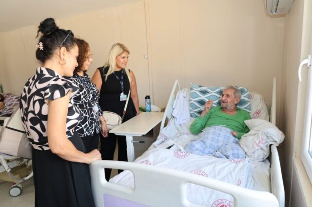 foto.jpg Hatay Büyükşehir Belediyesi yetkilileri huzurevi sakinlerine çiçek ve fidan verirken