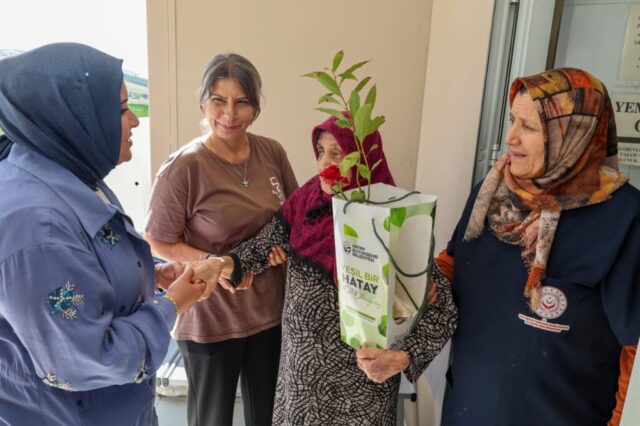 foto.jpg Hatay Büyükşehir Belediyesi yetkilileri huzurevi sakinlerine çiçek ve fidan verirken