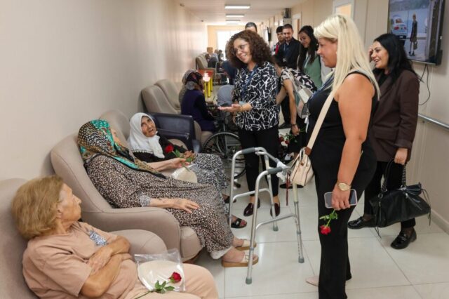 foto.jpg Hatay Büyükşehir Belediyesi yetkilileri huzurevi sakinlerine çiçek ve fidan verirken