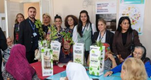 Hatay Büyükşehir Belediyesi yetkilileri huzurevi sakinlerine çiçek ve fidan verirken
