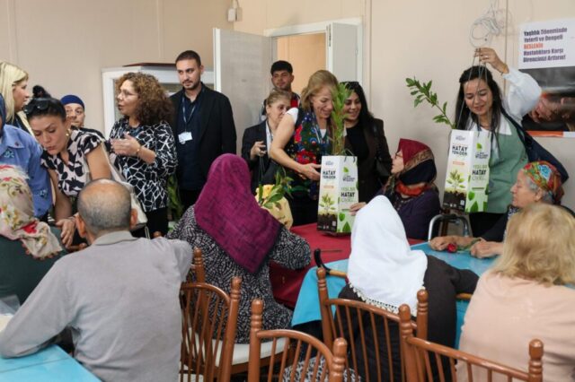 foto.jpg Hatay Büyükşehir Belediyesi yetkilileri huzurevi sakinlerine çiçek ve fidan verirken